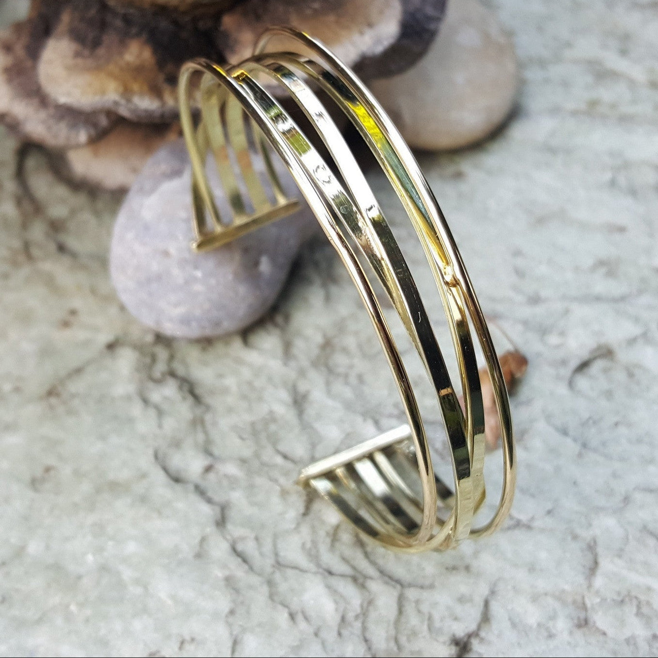 Dames armband van 14 karaat geelgoud. Weergegeven op een sfeervolle achtergrond. De gouden armband beschikt over een elegant lijnenspel. Ontdek alle armbanden voor dames bij Clary.
