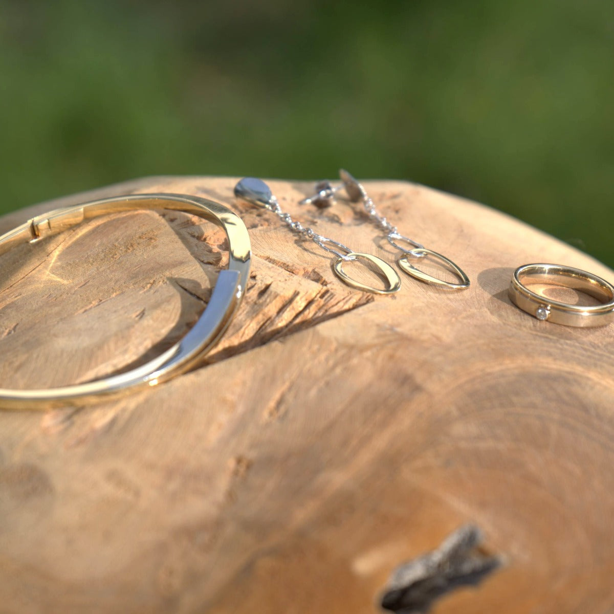 Gouden armband, bicolor oorbellen en een gouden ring met diamant, gefotografeerd voor de complete collectie van Clary.