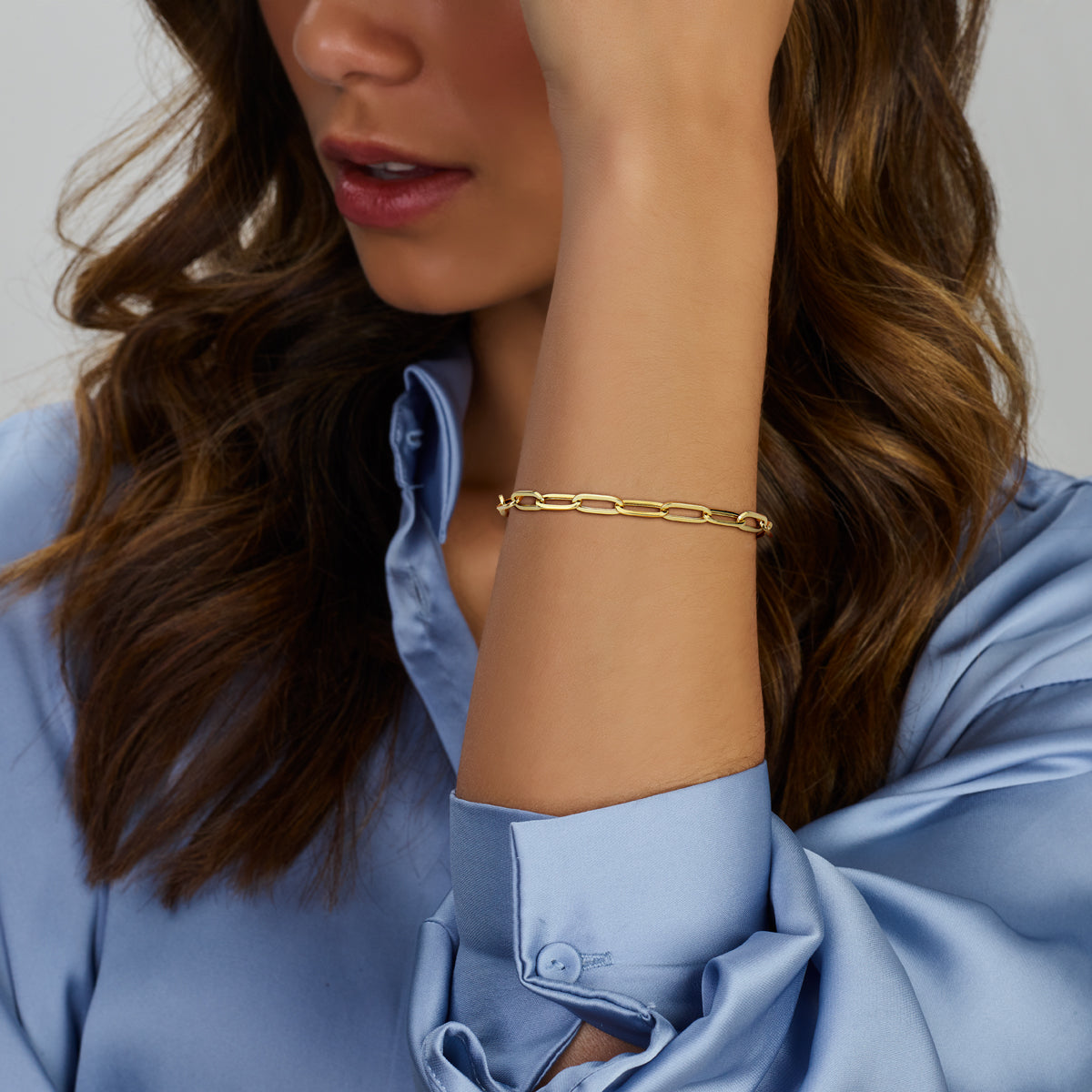 Nog een foto waarop het model de gouden paperclip armband van 14 karaat om de pols draagt.