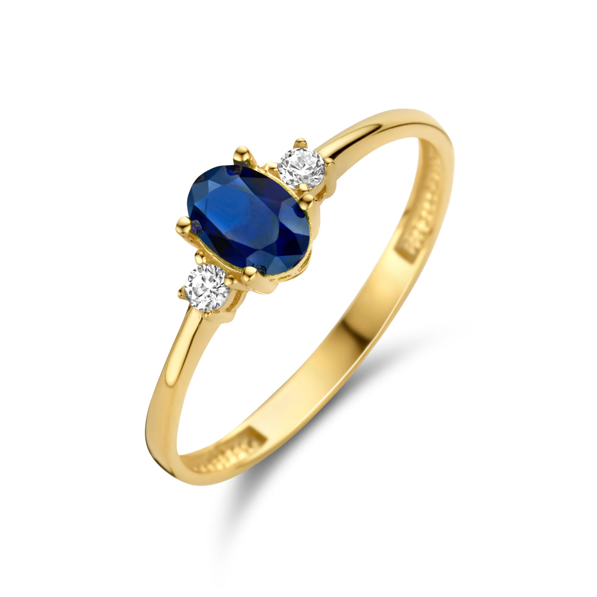 Schuin bovenaanzicht van de gouden trilogie ring met synthetische saffier van 14 karaat.