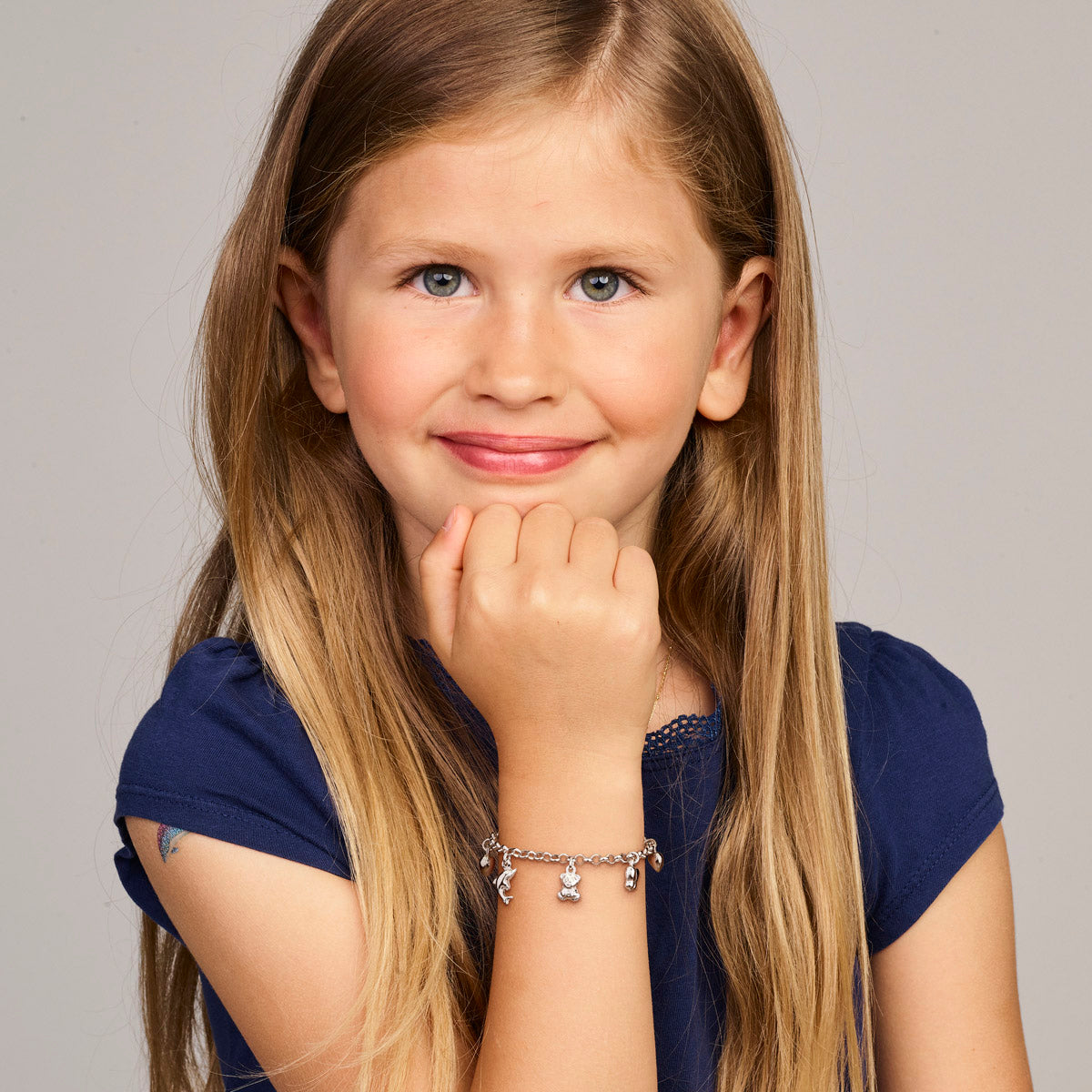 Model draagt de zilveren bedelarmband voor kinderen om de pols.