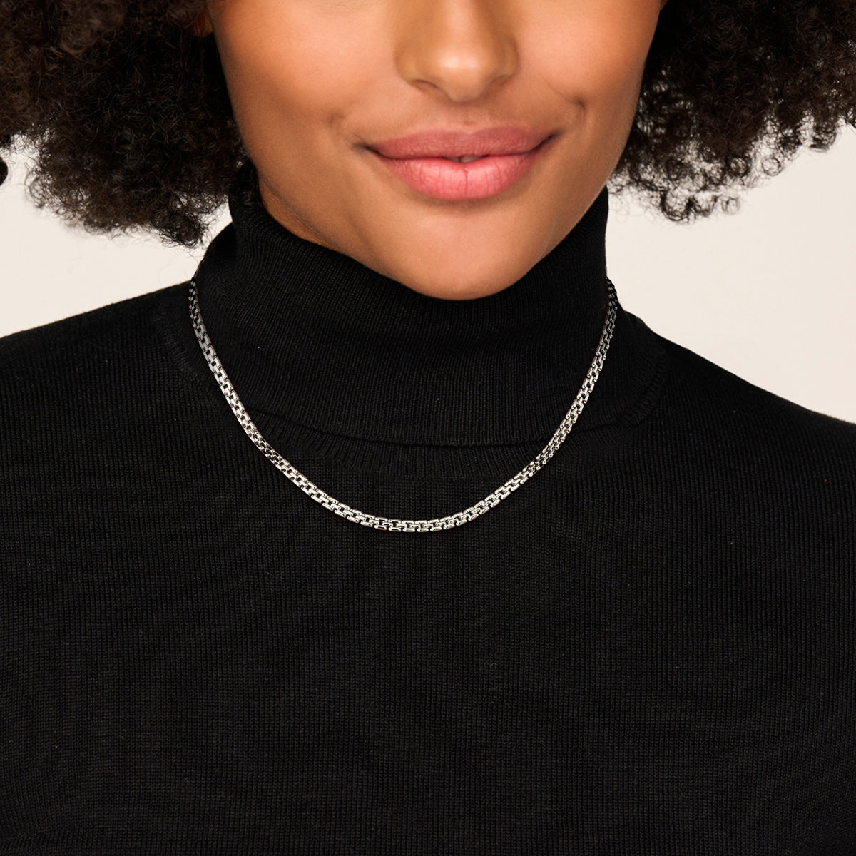 Zilveren schakelketting dames: model draagt de gerhodineerd zilveren schakelketting van 4,3 mm.