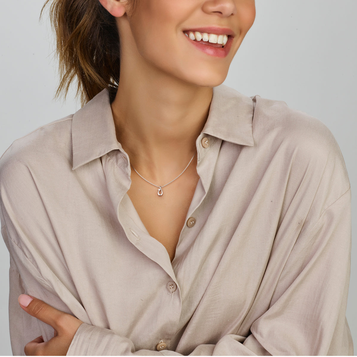 Model draagt de 925 gerhodineerd zilveren hanger met zirkonia aan een ketting om de hals.