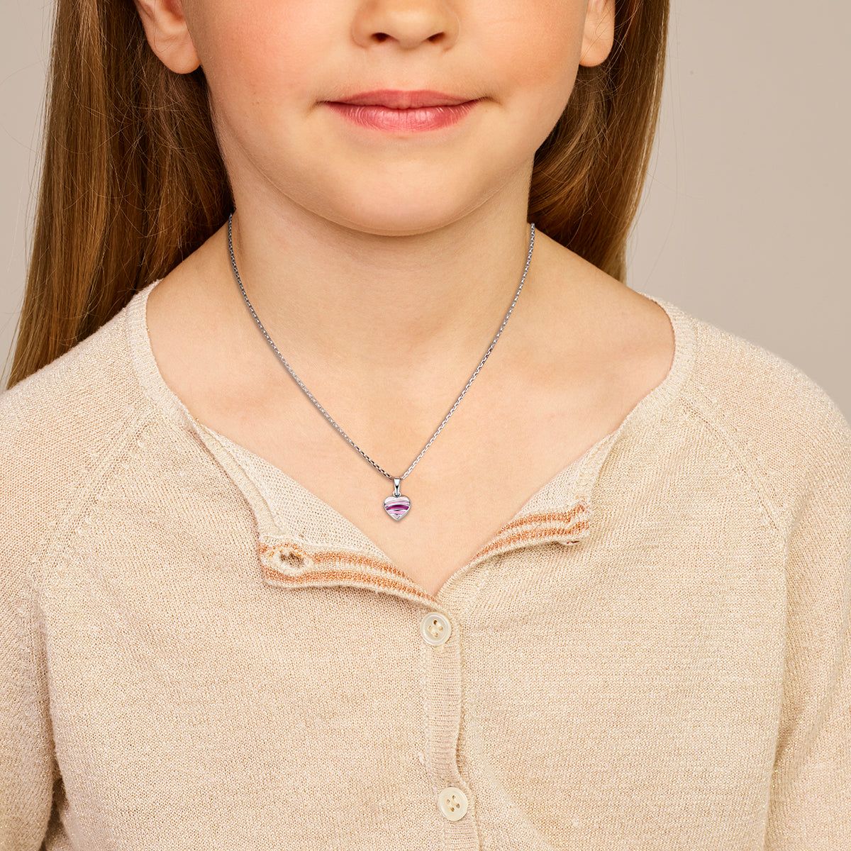 Kind draagt de 925 gerhodineerd zilveren kinderhanger hartje gestreept aan een ketting om de hals.