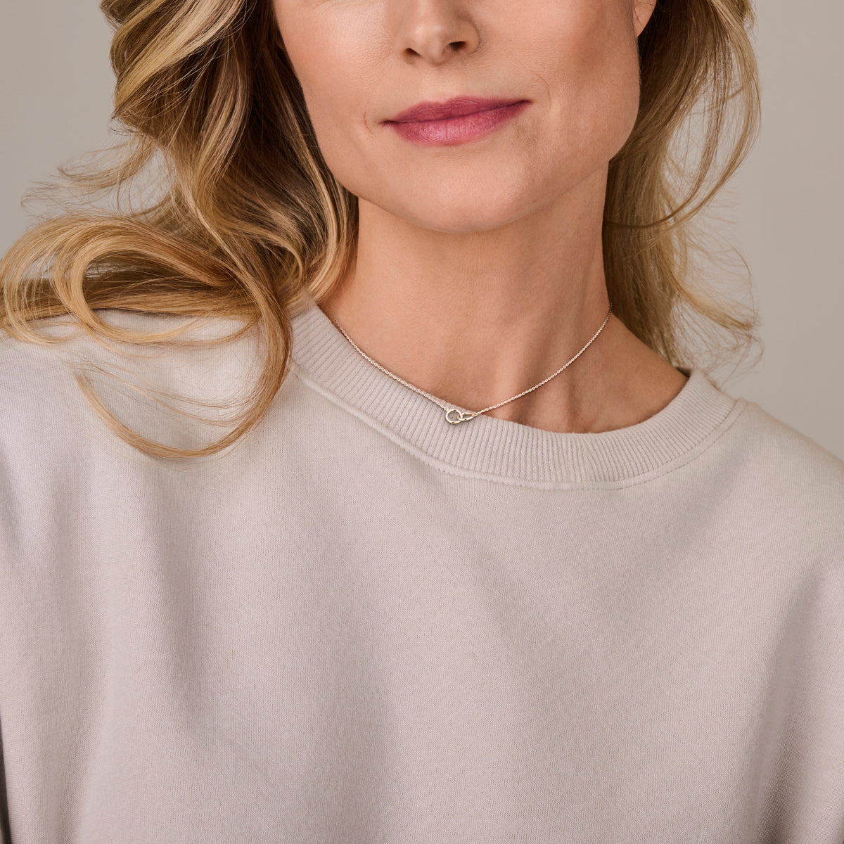 De verfijnde 'Enna' zilveren ketting met cirkels gedragen door een model voor een elegante uitstraling.