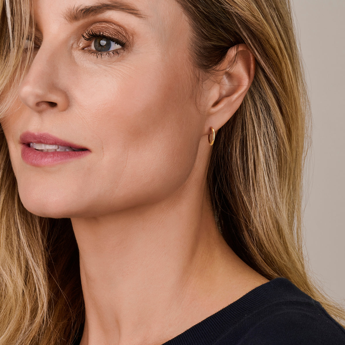 Een model draagt de 17 mm 'Sophie' oorringen, die iets losser om de oorlel vallen voor een klassieke look.