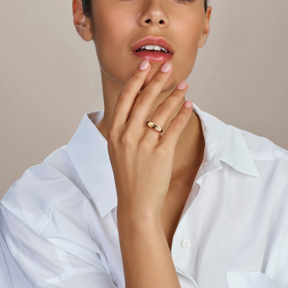 Een model draagt de klassieke 14 karaat gouden Trinity ring.