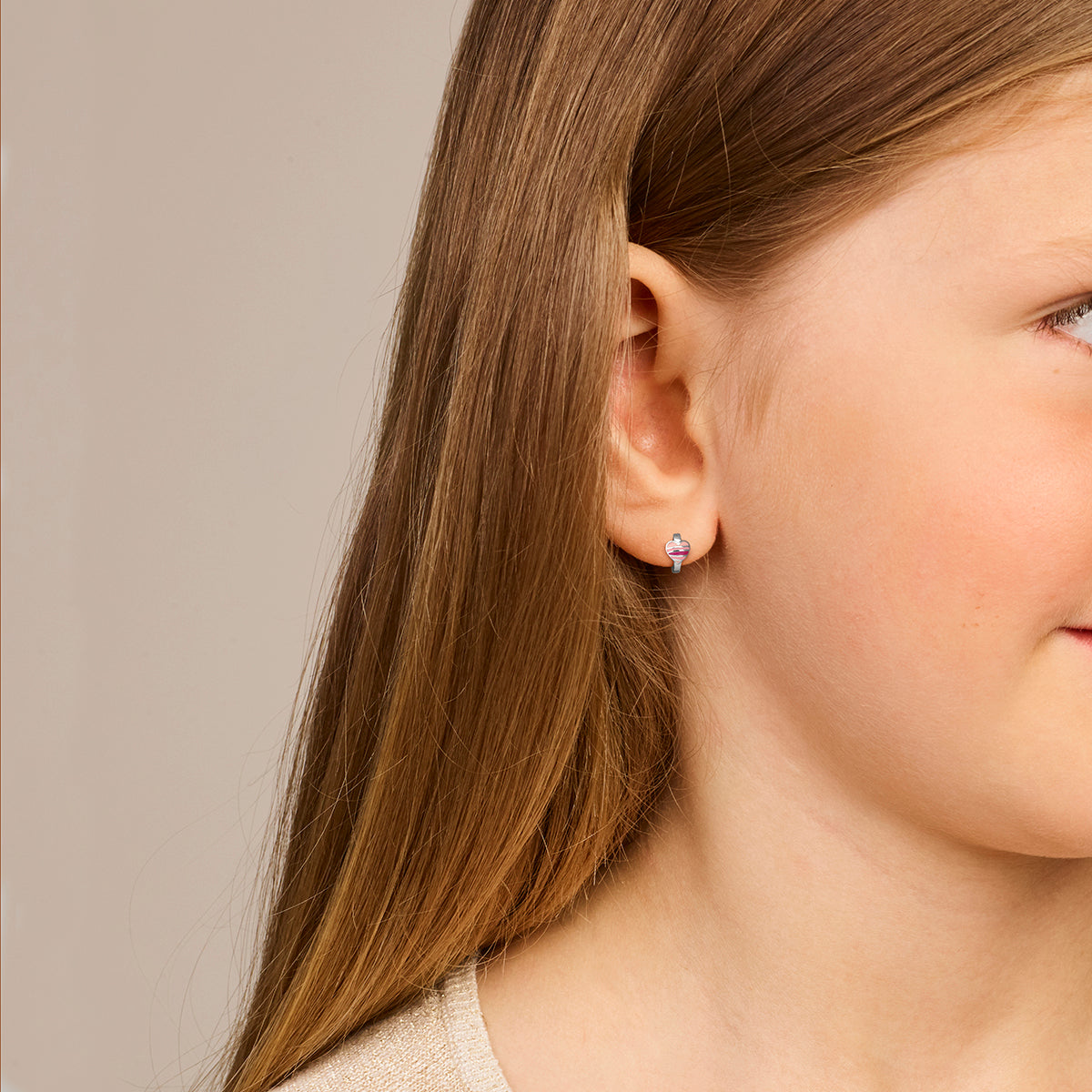 Een kind model draagt de 'Liva' klapoorringen om te laten zien hoe ze staan.