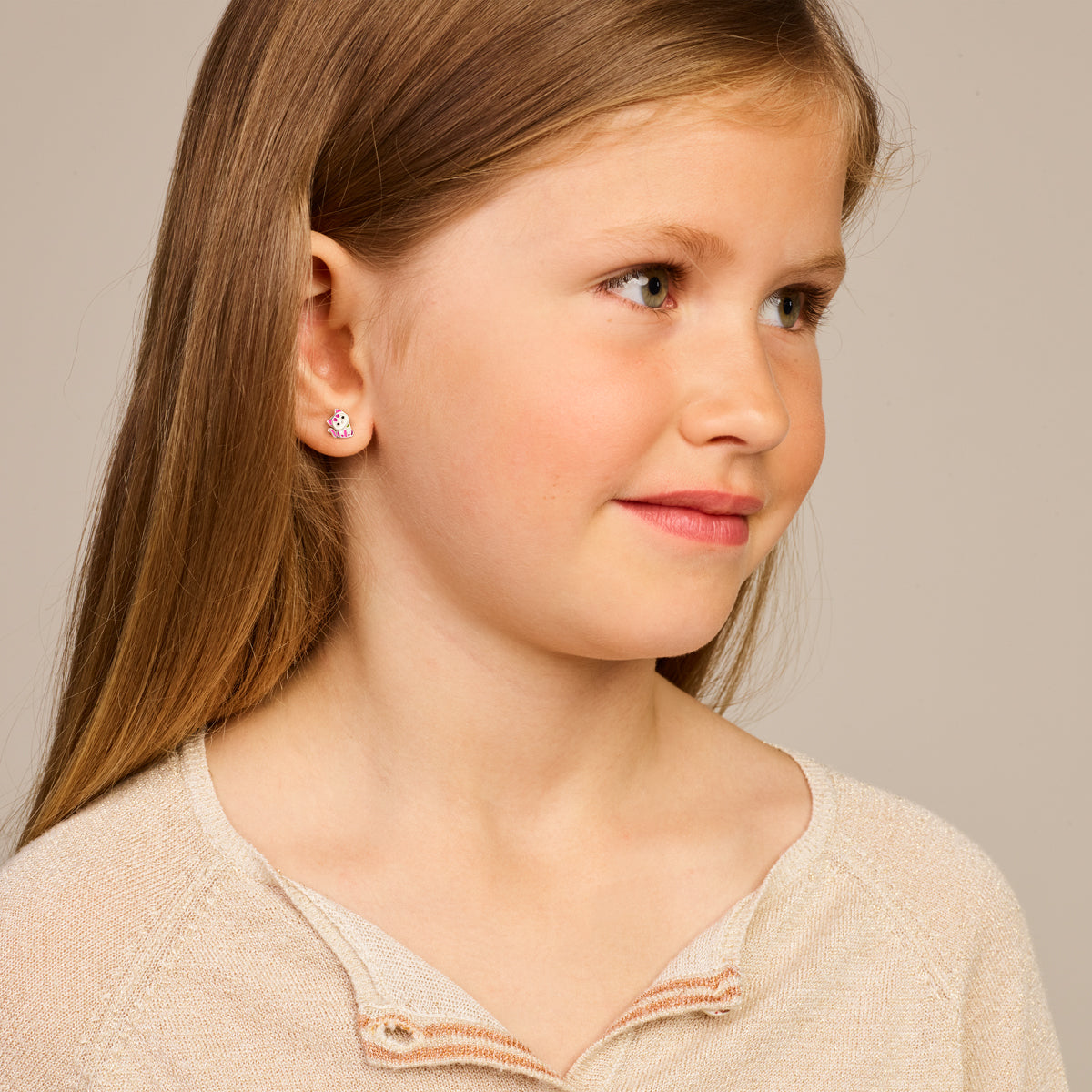 Een kind model draagt de 'Mio' oorknopjes zodat je goed ziet hoe ze staan.