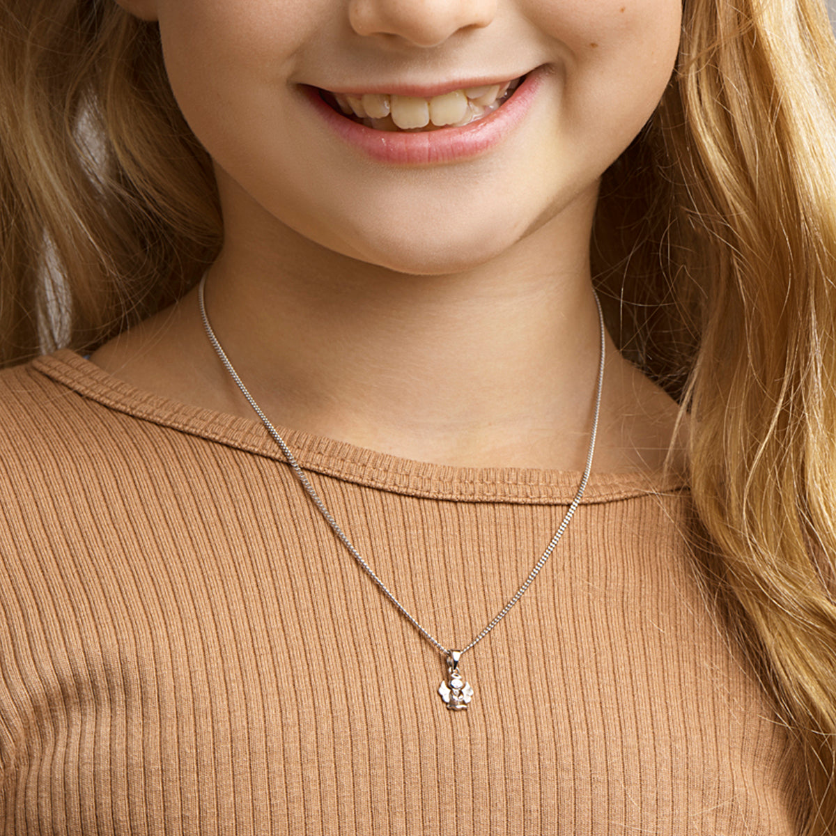 Een kind model draagt de 'Sia' hanger om de grootte en lengte te tonen.