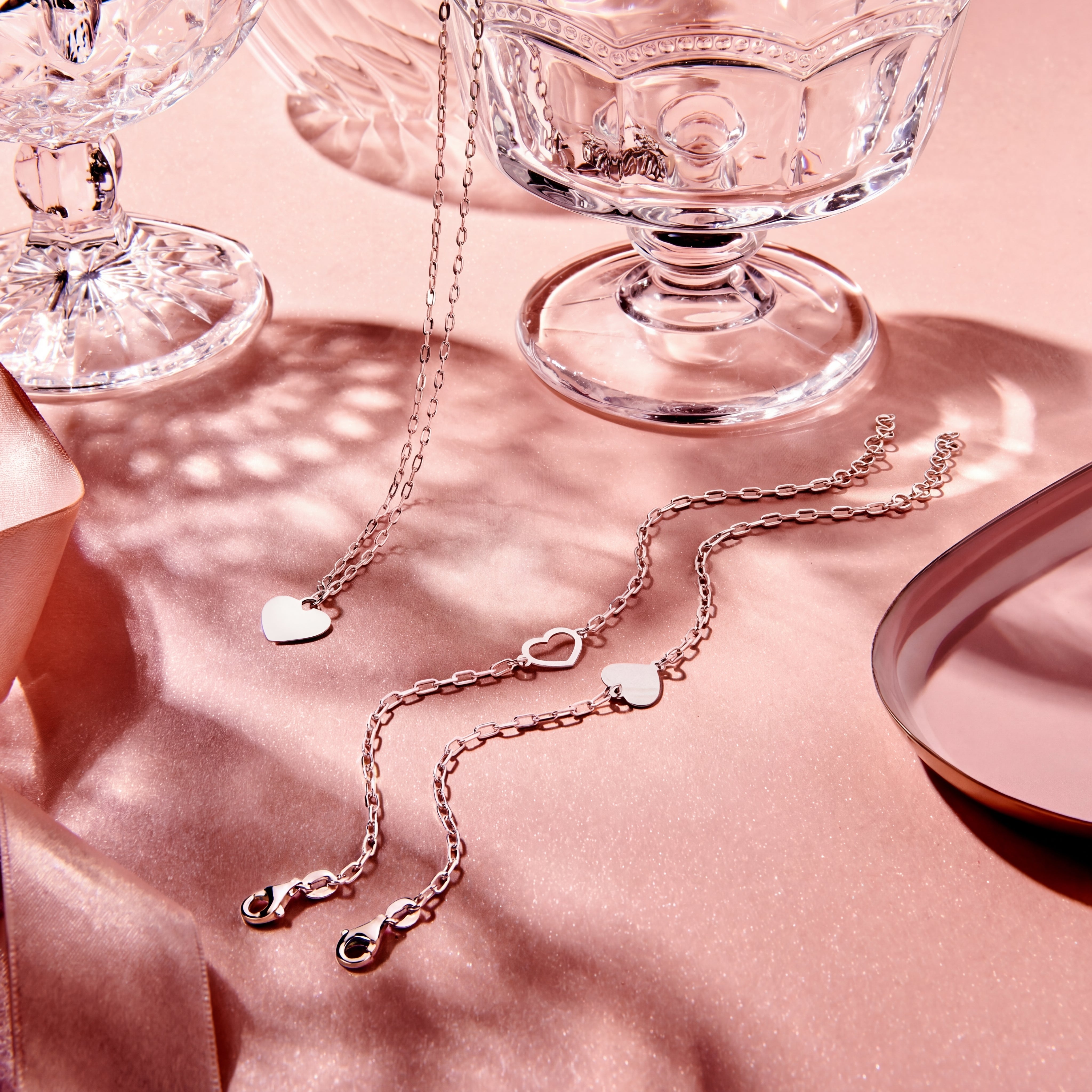Close-up van het dichte zilveren hartje maar ook een andere zilveren armband en collier met hartje.