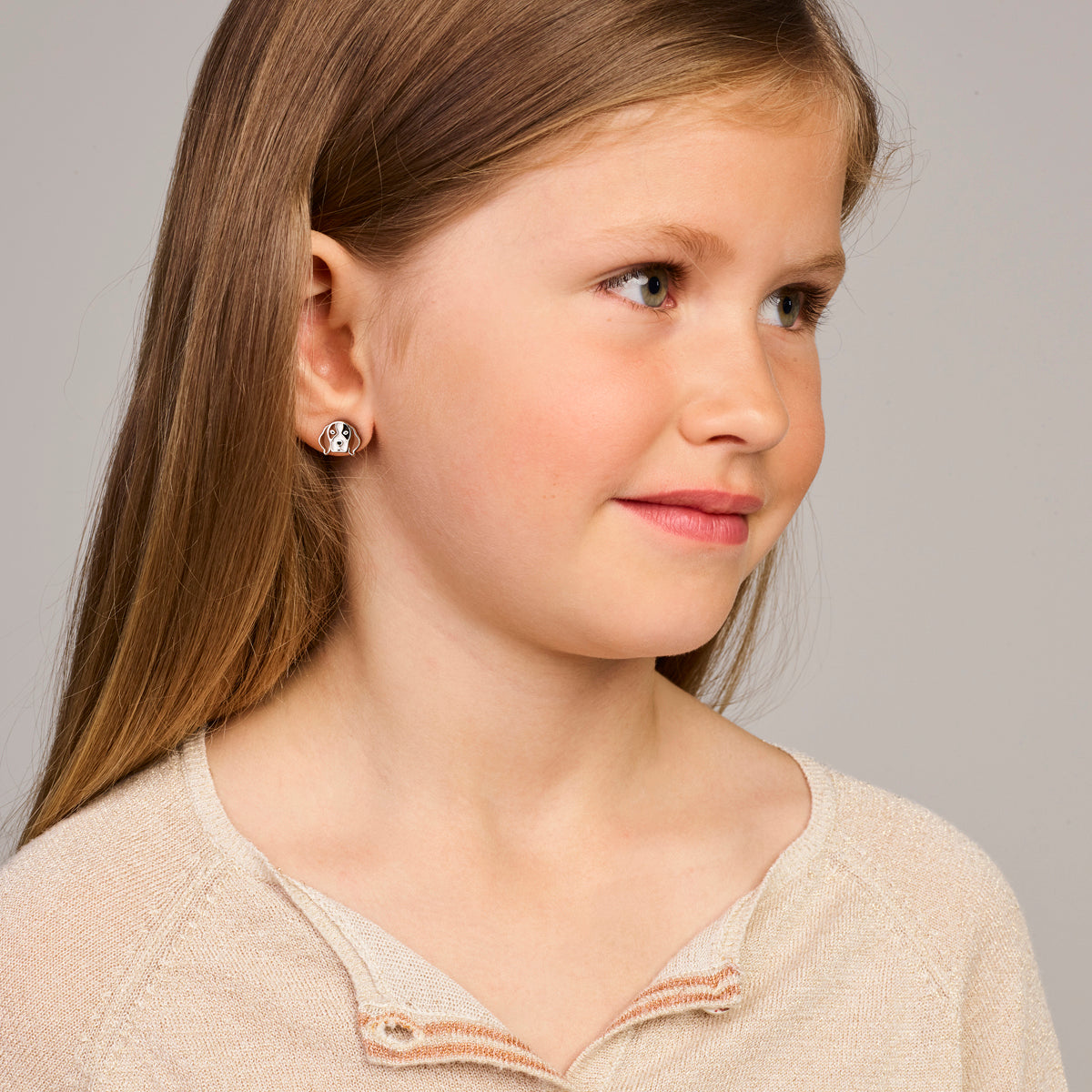 Een kindermodel draagt de zilveren kinderoorknoppen Luna in de vorm van een hondje.