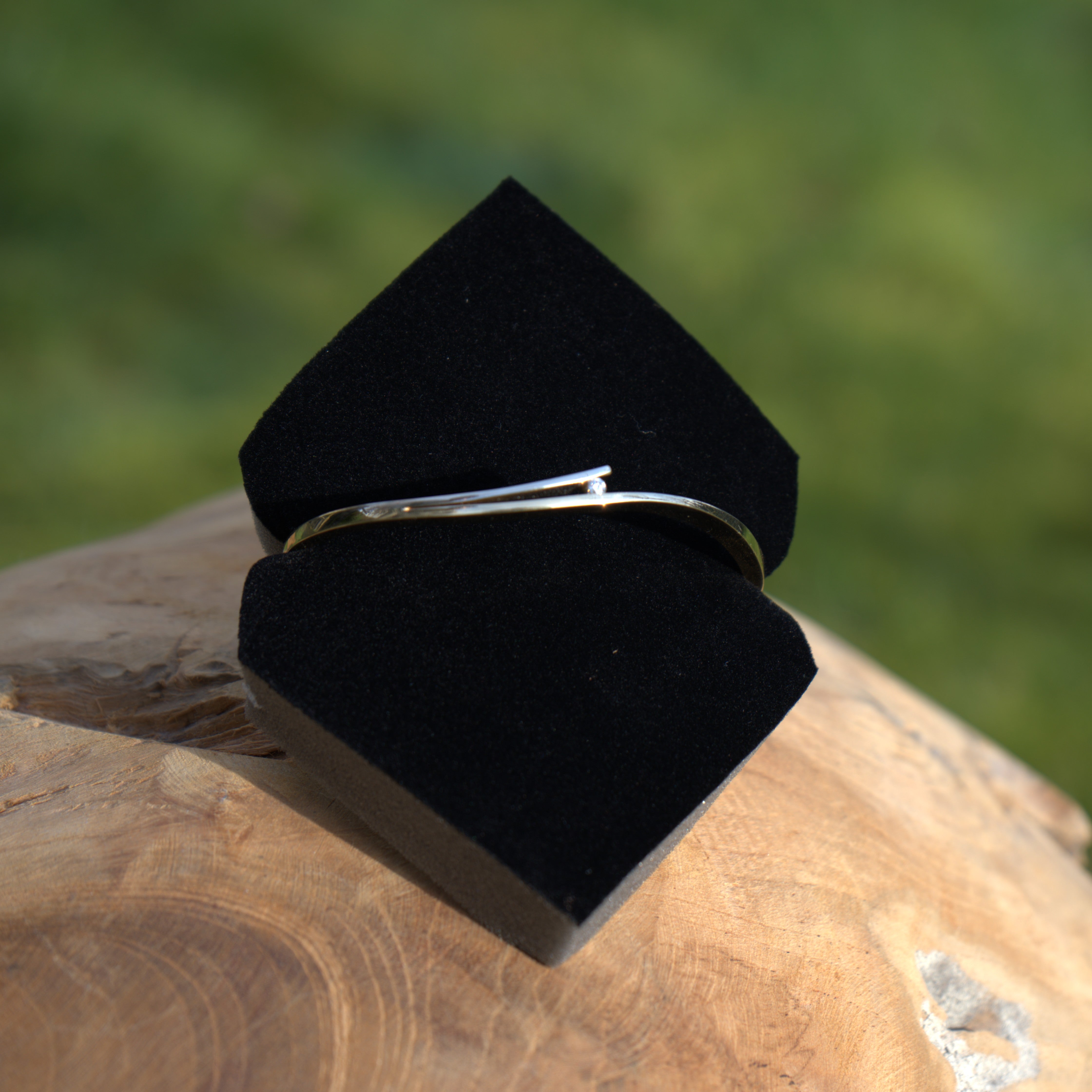 Een verfijnde gouden armband van witgoud en geelgoud met een betrouwbare sluiting en een subtiele diamant. Elegant gepresenteerd in een natuurlijke setting. Ontdek alle armbanden bij Clary.