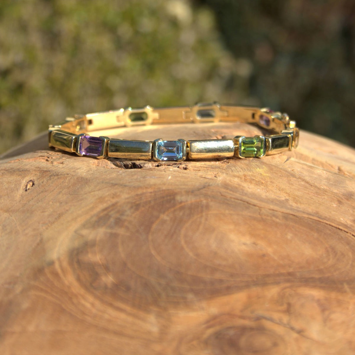 Geelgouden armband met gekleurde edelstenen waaronder amethist, blauwe topaas en peridot, bij Clary.