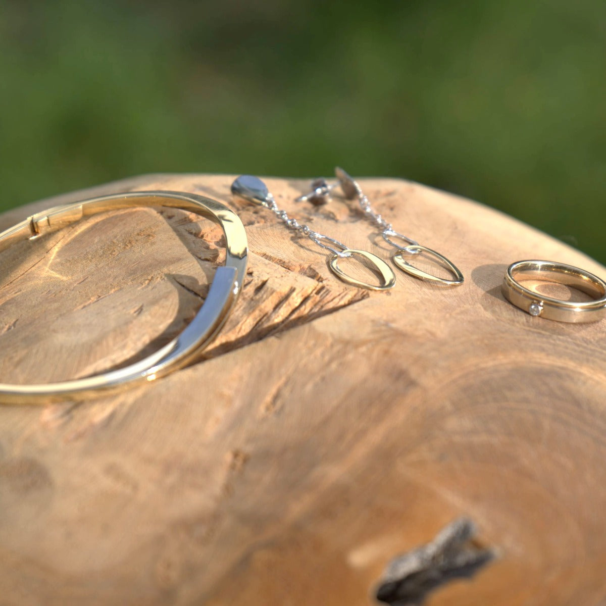 Gouden armband, bicolor oorbellen en een gouden ring met diamant als onderdeel van de dames sieraden collectie bij Clary.