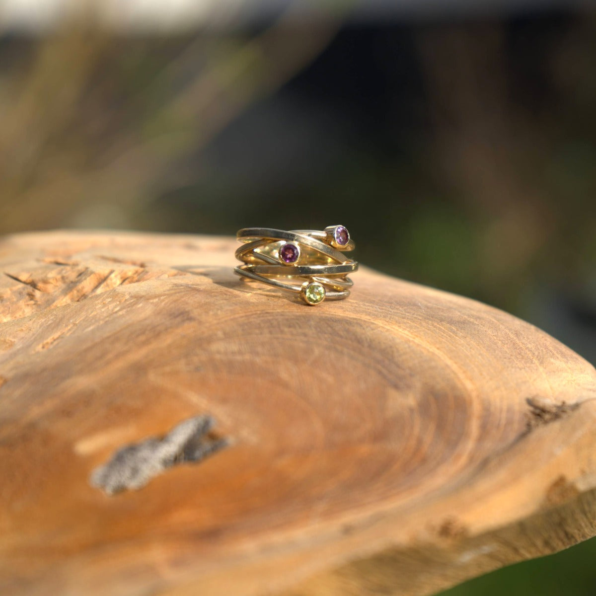 Close-up van een gouden ring met drie edelstenen, uit de dames ringen collectie bij Clary.