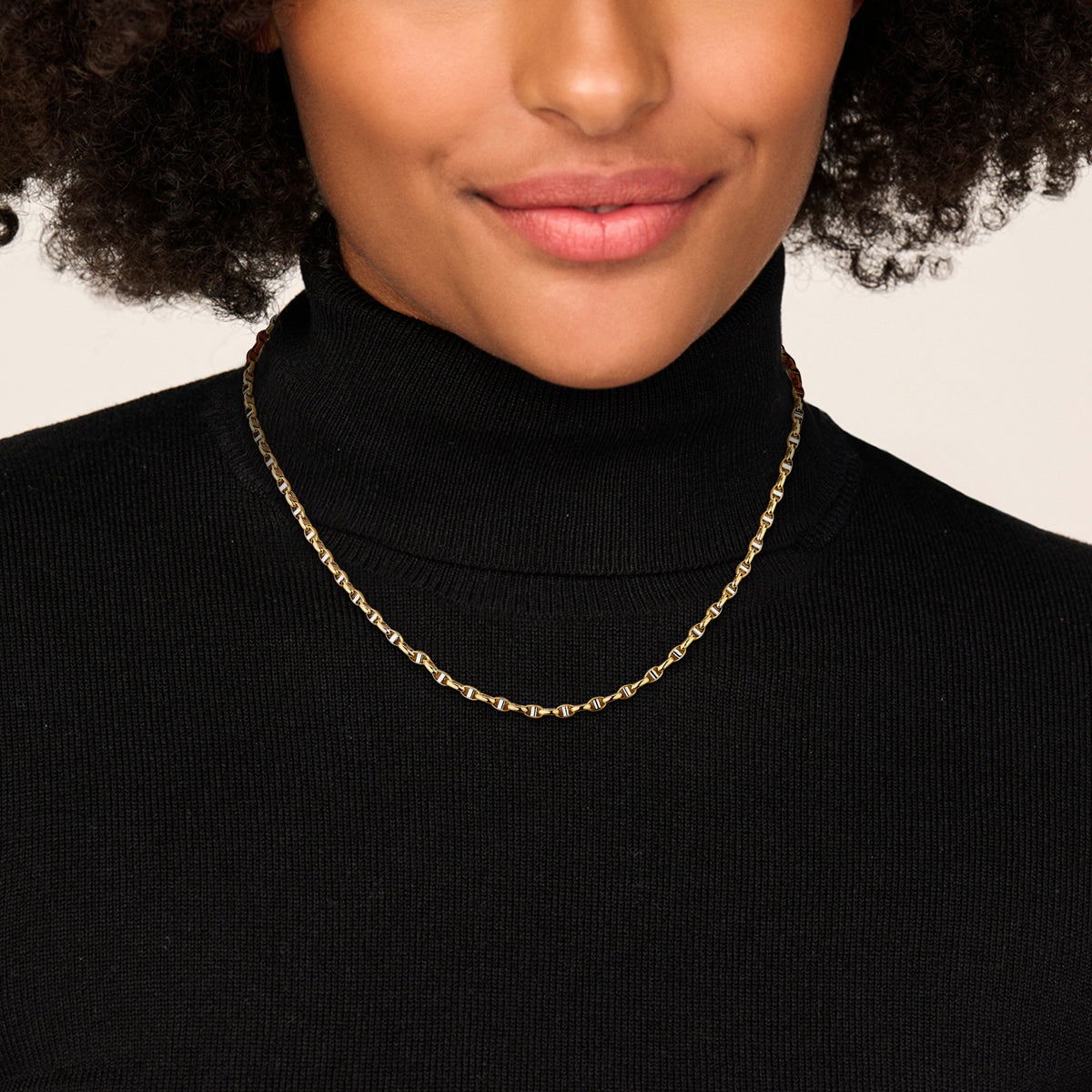 Bicolor ketting: model draagt de 14 karaat bicolor gouden ovale jasseron halsketting met balkje van 3,5 mm breed, lengte 45 cm