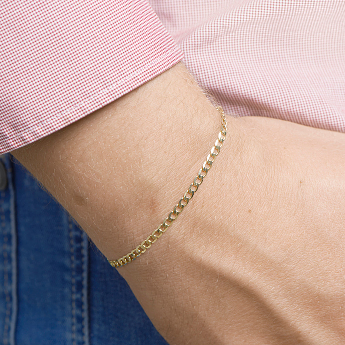 Gouden gourmet armband: model draagt de 14 karaat geelgouden 6-zijdig geslepen gourmette armband van 3,3 mm breed, lengte 20 cm