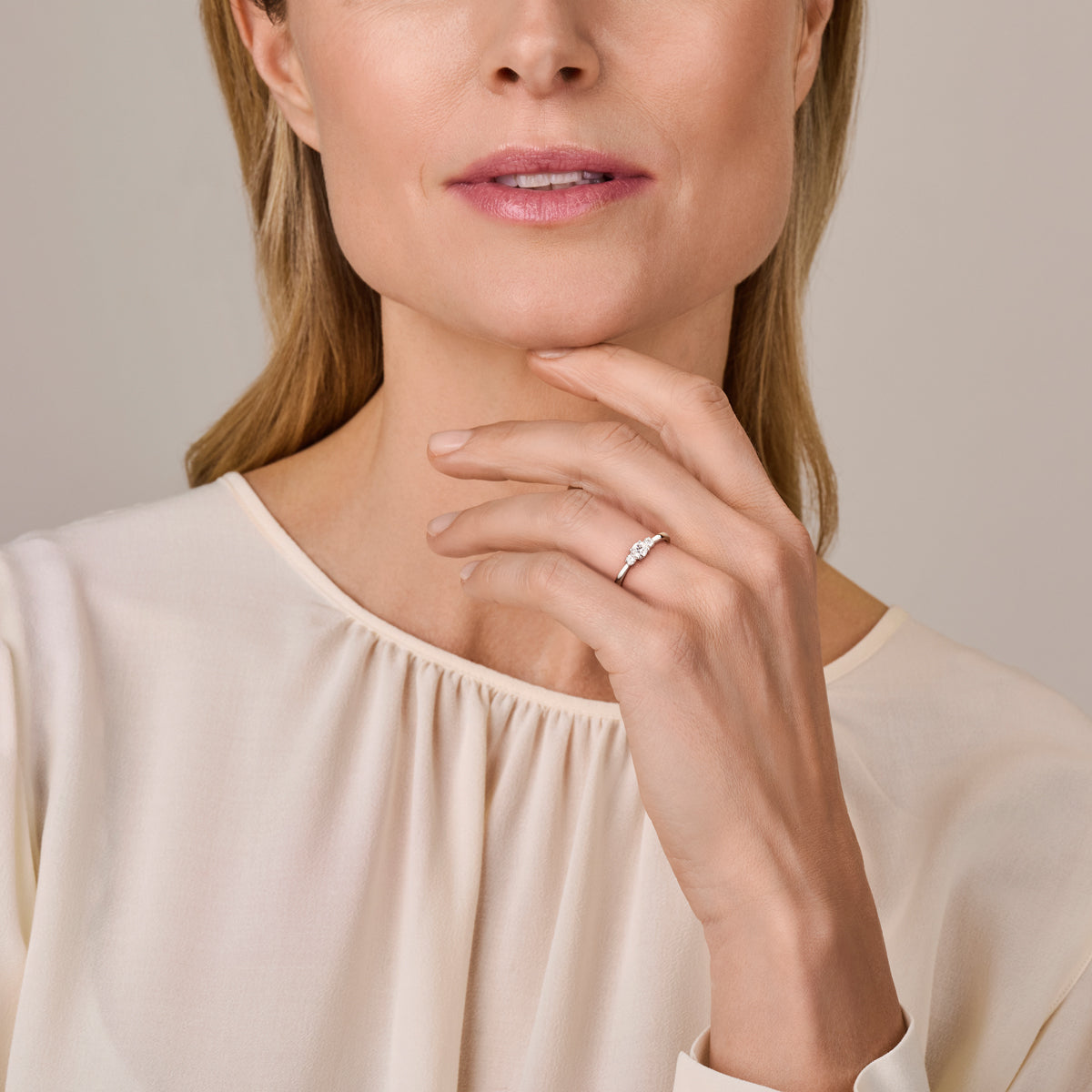 Model draagt de witgouden trilogie ring met lab grown diamant van 14 karaat aan de hand.