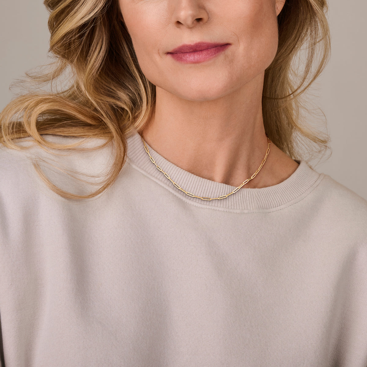 Een model draagt de 18k gouden 'Kate' ketting, die opvalt door de diepe, warme goudkleur en glanzende afwerking.