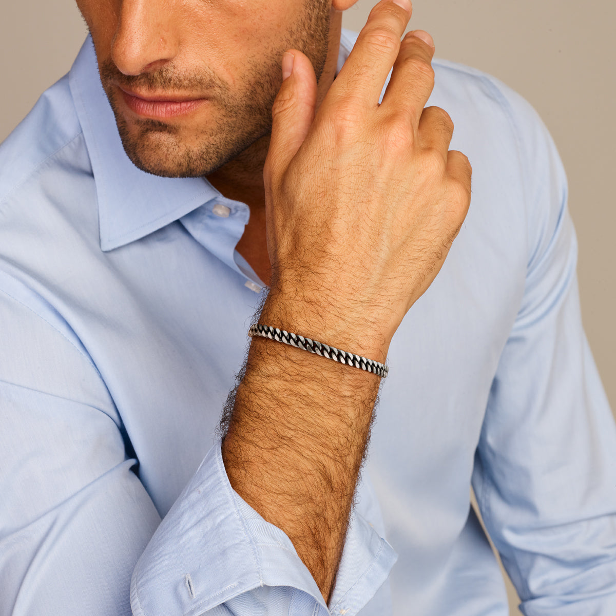 Model draagt de geoxideerd zilveren gourmet armband voor heren van 19 cm om de pols.