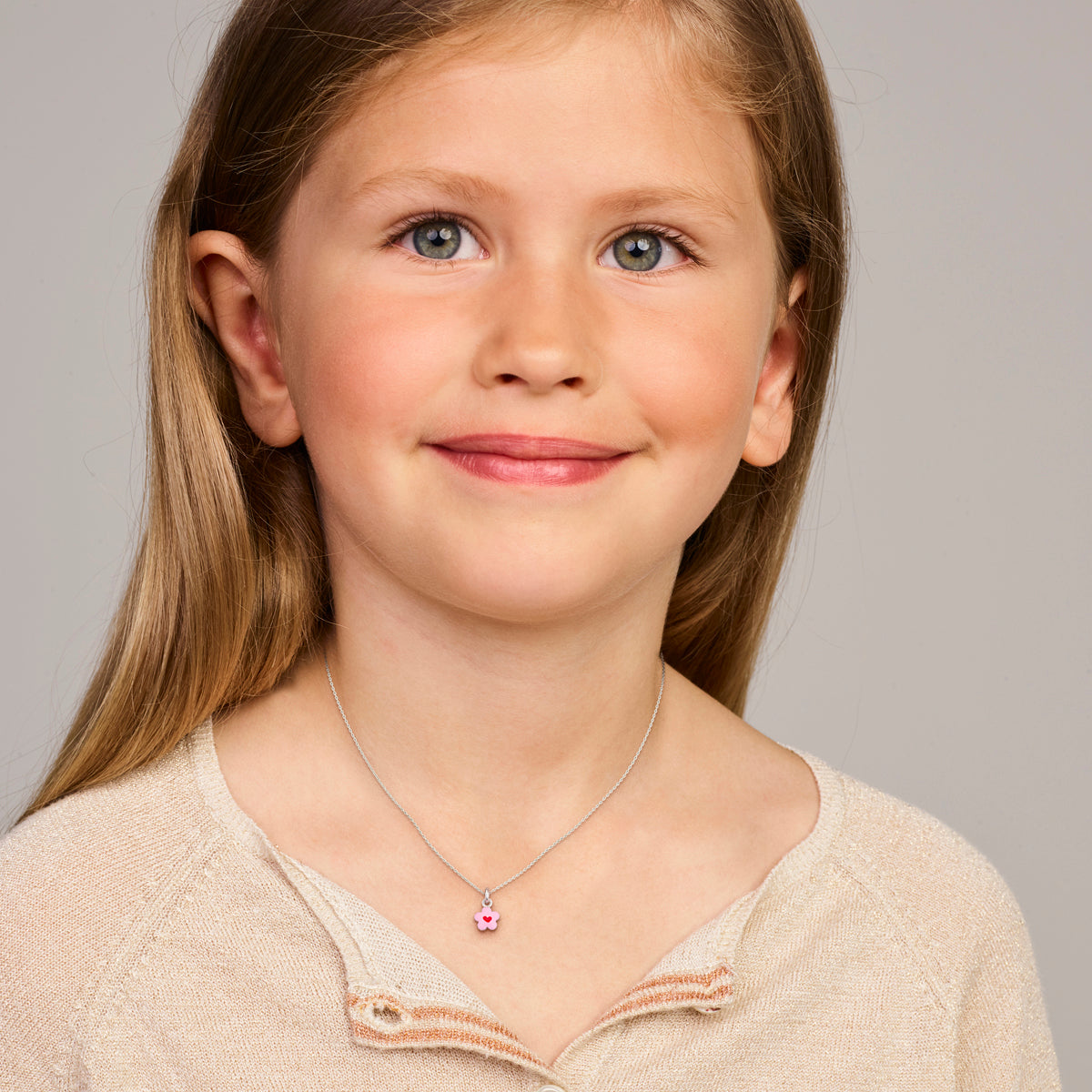 Model draagt de zilveren bloem kinderhanger met emaille om de hals.