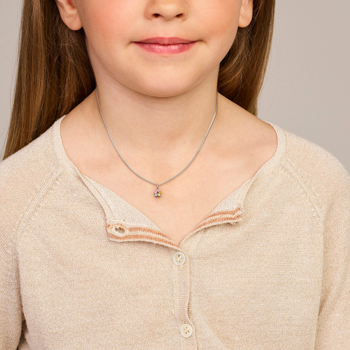 Model draagt de zilveren bloem kinderhanger met emaille om de hals.