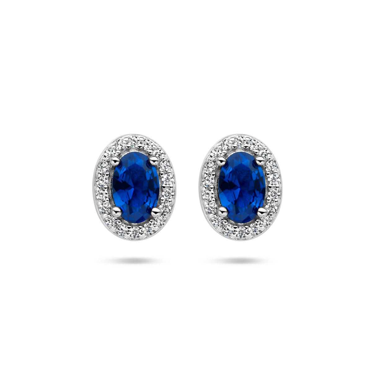 Vooraanzicht van de zilveren halo oorknopjes met blauwe zirkonia.