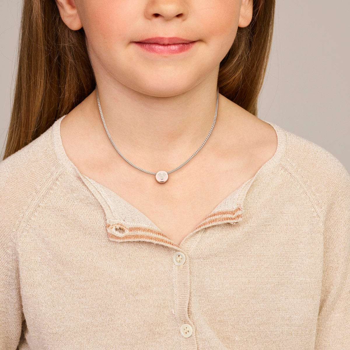 Model draagt de zilveren roze hartje kinderhanger met zirkonia om de hals.