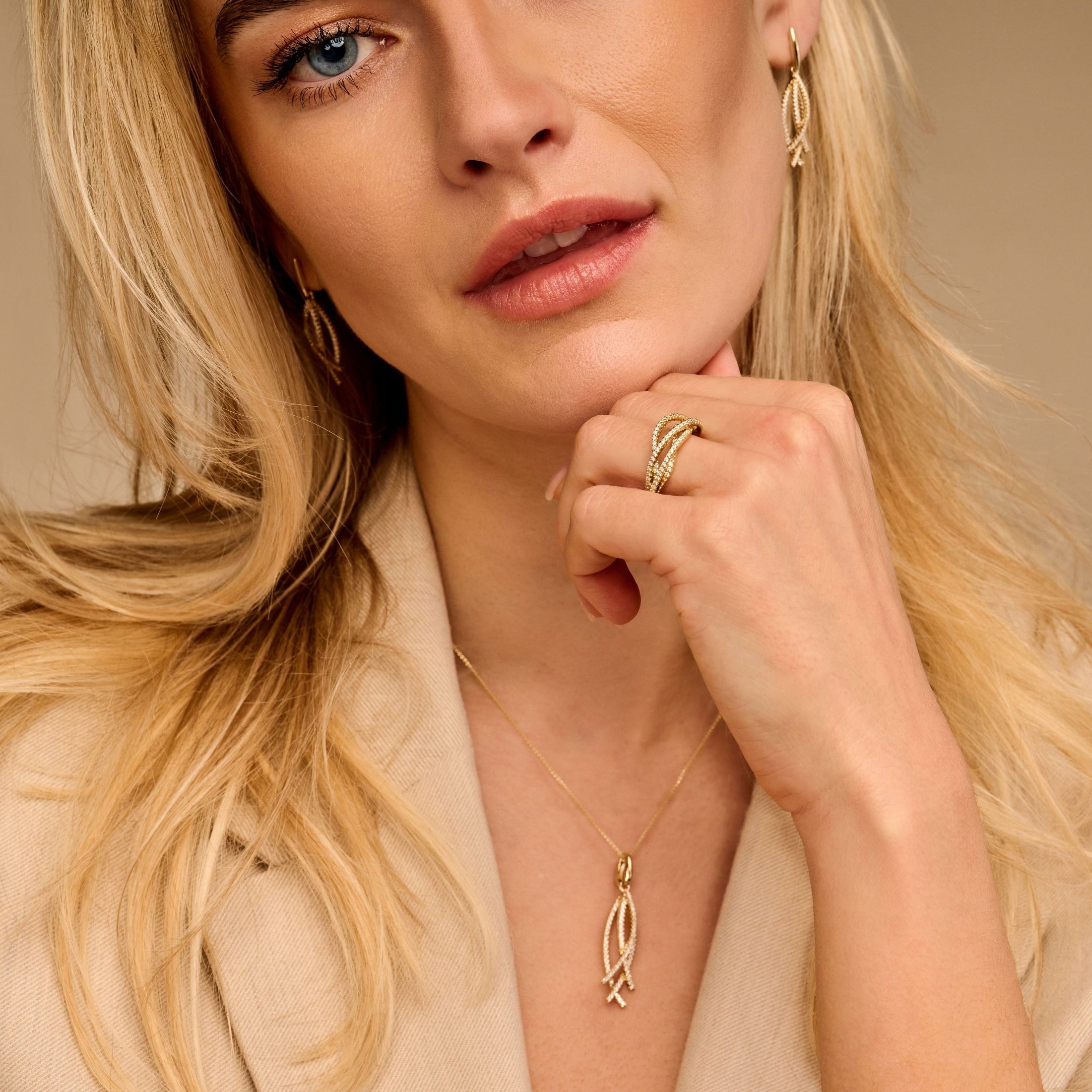 'Vyne' setje gedragen door een model. Geeft een weergave van de geelgouden 14 karaat hanger, ring en oorhangers. Bezet met diamanten voor een luxe uitstraling. Ontdek het bij Clary, juwelier en goudsmid.