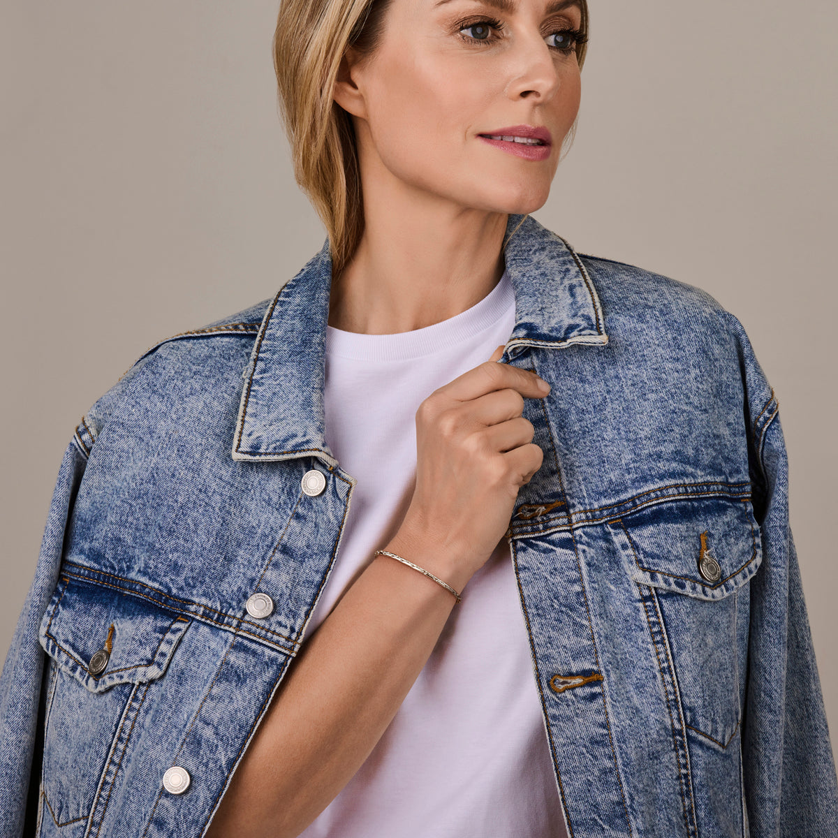 De verfijnde 'Brio' zilveren Cardano-armband om de pols gedragen, toont de soepele valling en glans.