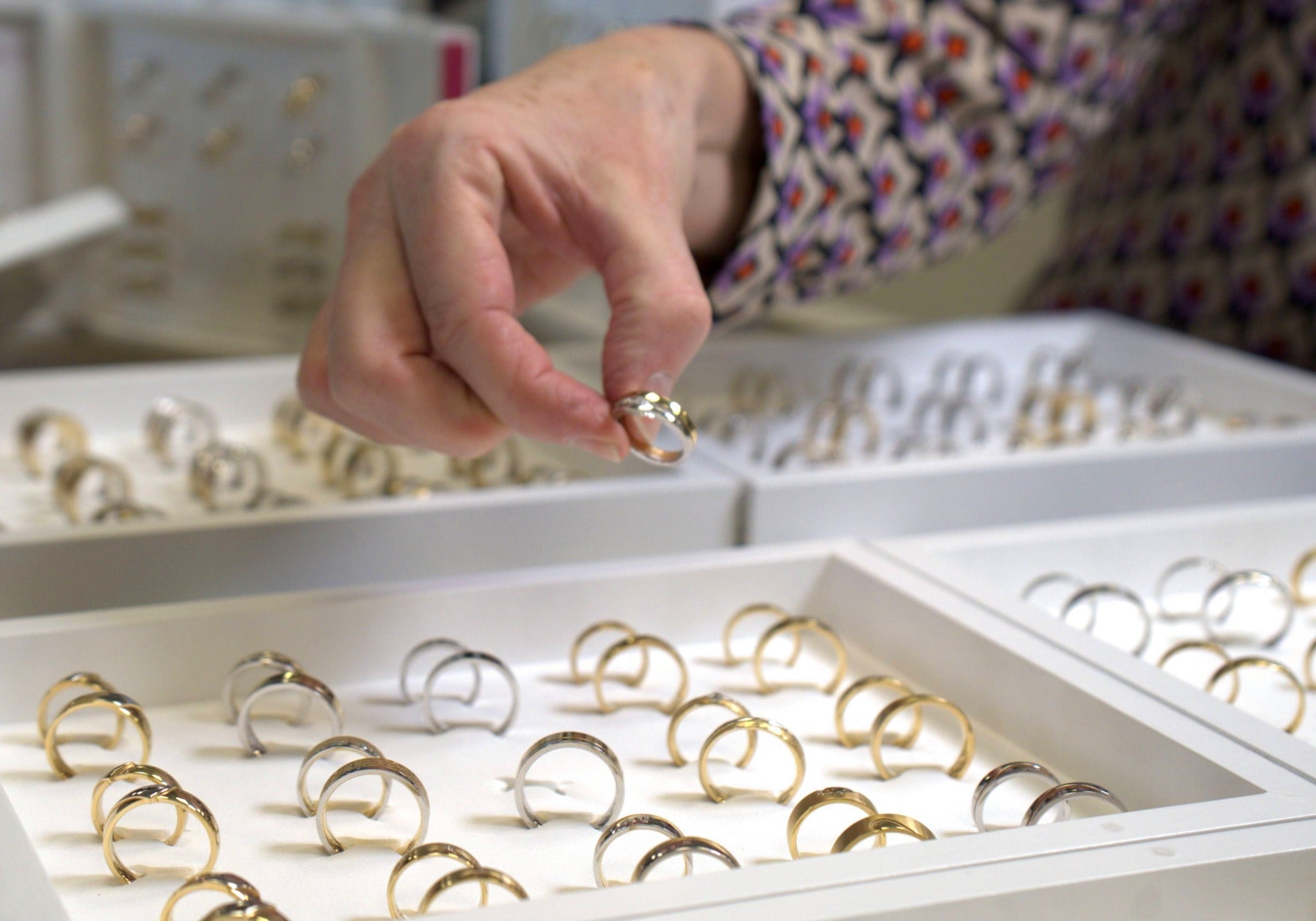 Clary houdt een trouwring vast in een sfeervolle setting bij Clary Juwelier-Goudsmid.