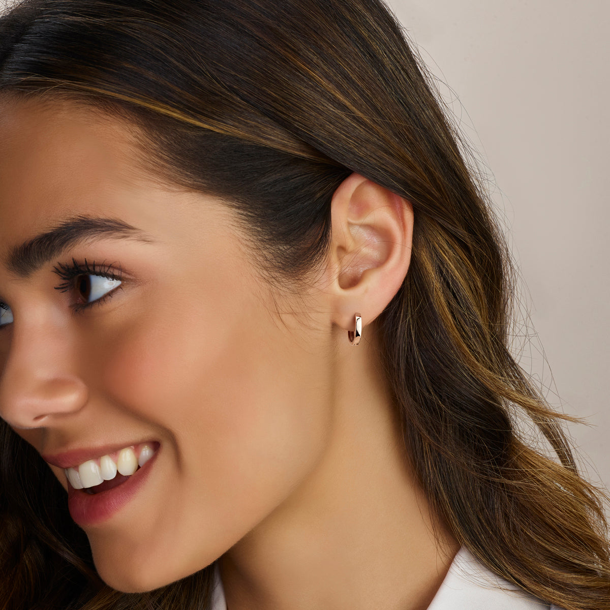 De moderne 'Iva' zilveren klapoorringen van 15 mm gedragen in het oor voor een tijdloze look.