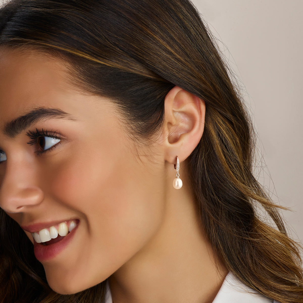 Elegante zilveren 'Maren' pareloorhangers gedragen door een model tonen de verfijnde hoogte van 29 mm en de zachte glans van de parels.