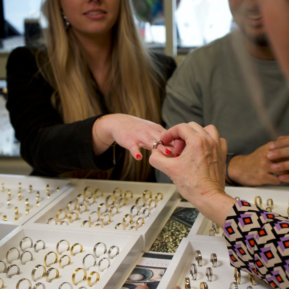 Stelletje bekijkt verlovingsringen bij juwelier-goudsmid Clary, persoonlijk advies op afspraak.