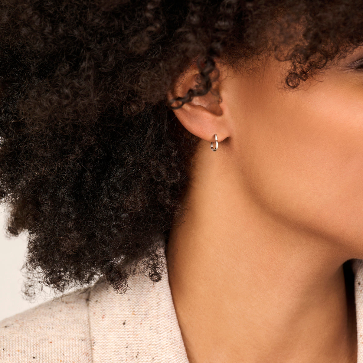 Een model draagt de kleinste maat 'Bella' oorringen voor een subtiele look.